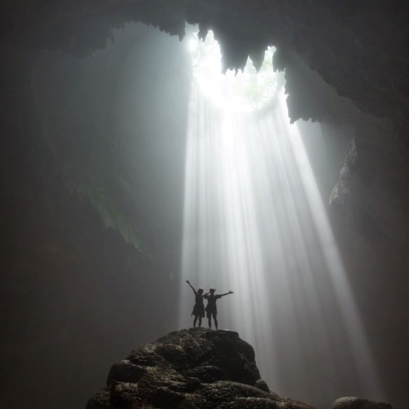 Visitors standing in a beam of light.